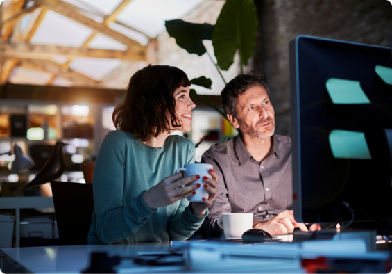 Two colleagues collaborating on a project, looking at computer screen.