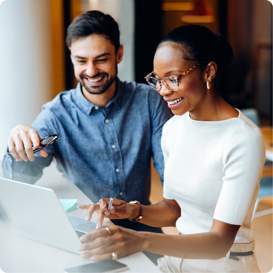 Two colleagues collaborating on a project, looking at laptop screen.