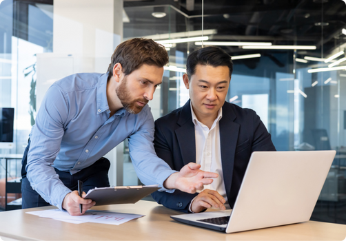 Two colleagues collaborating on a project, looking at laptop screen.