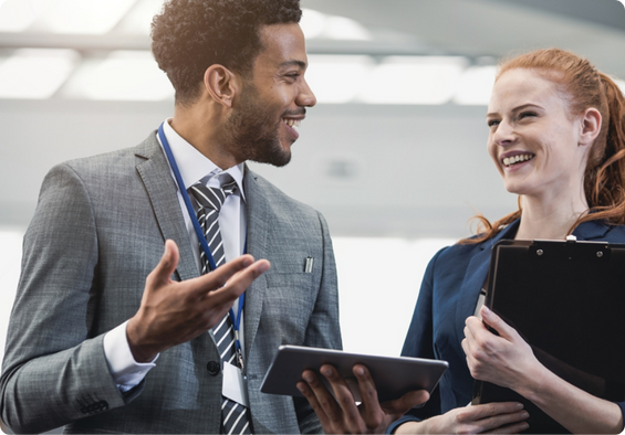 Two colleagues walking looking at tablet screen.