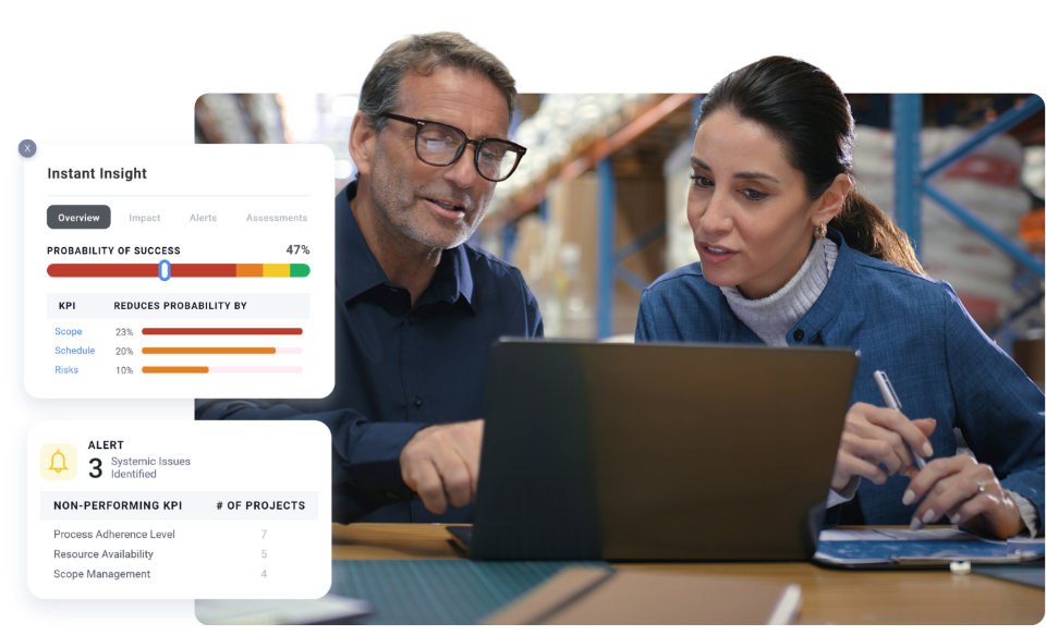 Two colleagues collaborating on a project, looking at laptop screen.