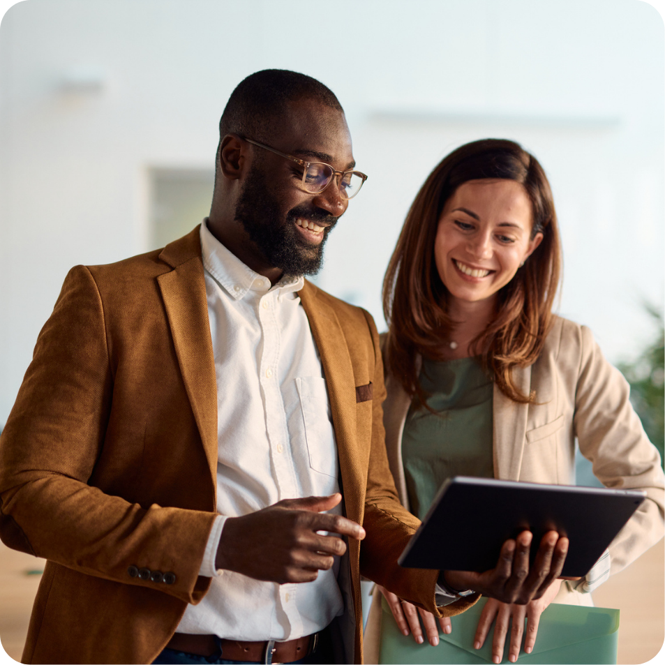 Two colleagues collaborating on a project, looking at tablet screen.
