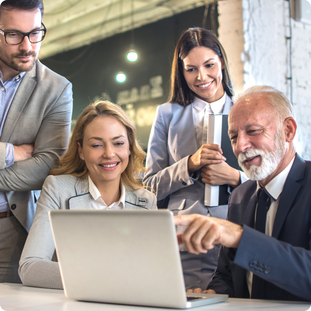Group of colleagues collaborating on a project, looking at laptop screen.