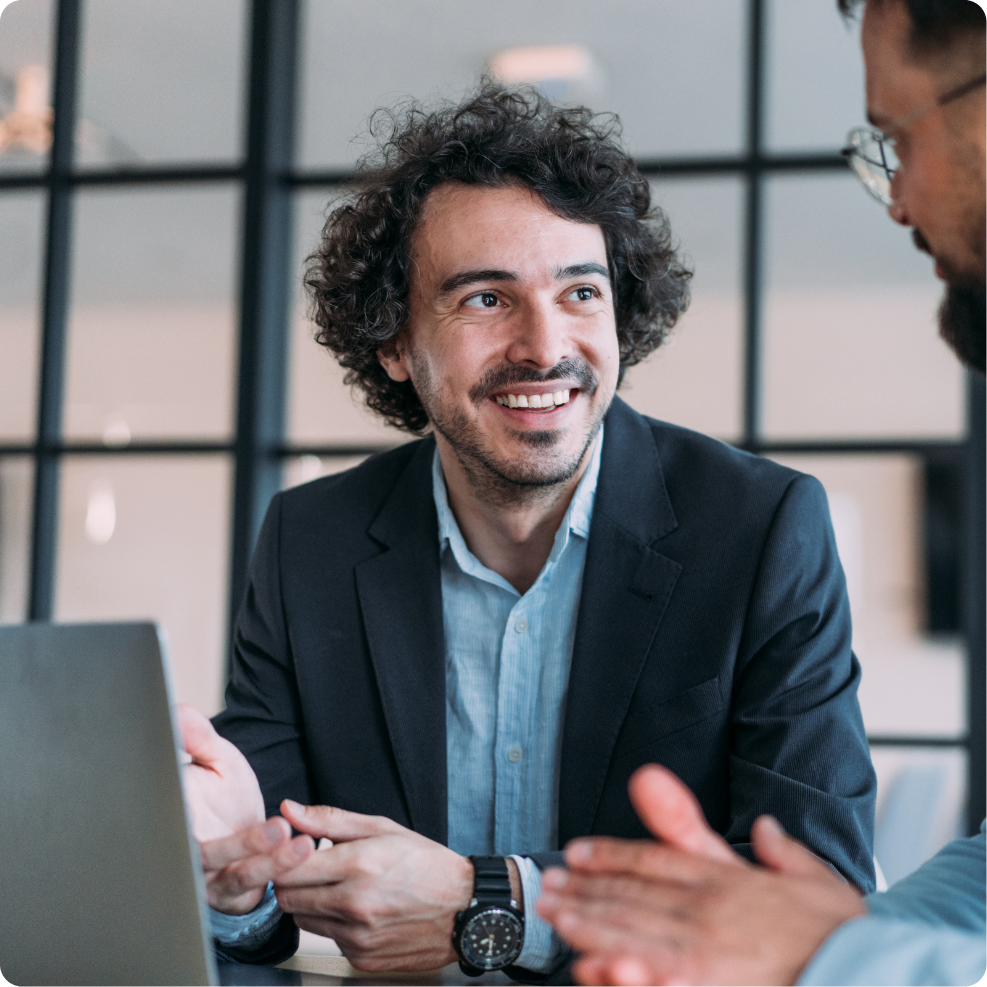 Two colleagues collaborating on a project, looking at laptop screen.