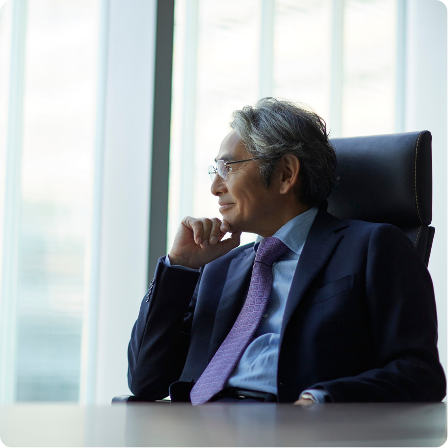 Professional looking outside a window sitting at a desk.