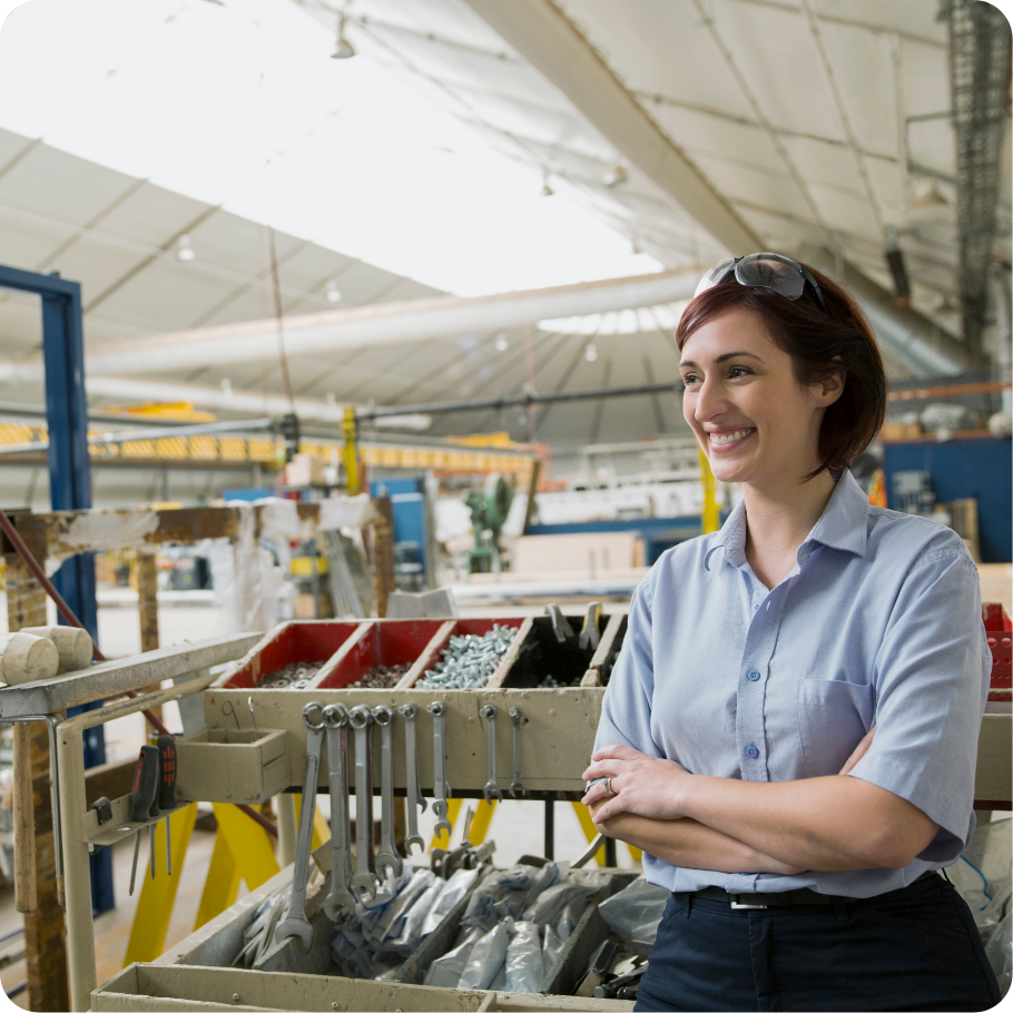 Professional standing in manufacturing setting.