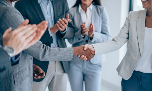 Group of professionals standing in an office setting.