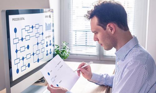 Professional looking at computer monitor in office setting.