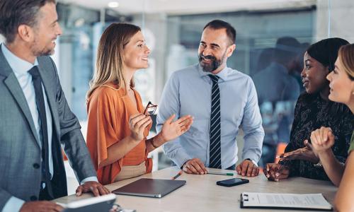 Group of professionals standing in an office setting.
