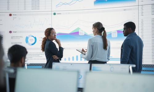 Group of professionals standing in an office setting.