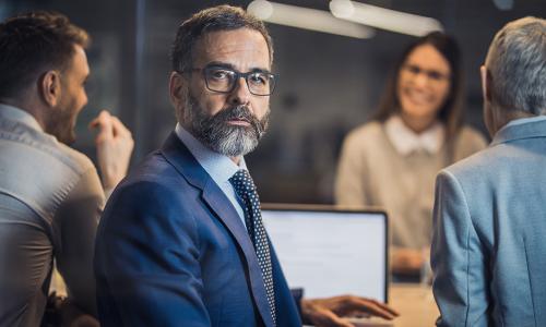 Professional looking at computer monitor in office setting.