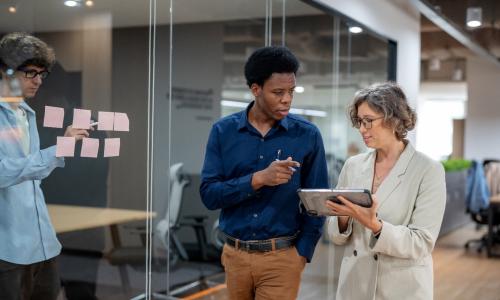 Two professionals walking in an office setting.