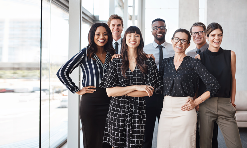 Group of professionals standing in an office setting.