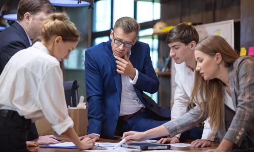 Group of professionals standing in an office setting.