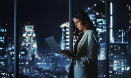 Professional looking at tablet in office setting.