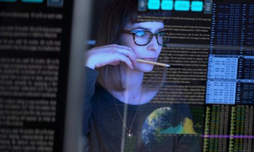 Professional looking at computer monitor in office setting.