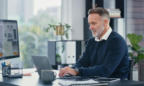 Professional looking at computer monitor in office setting.