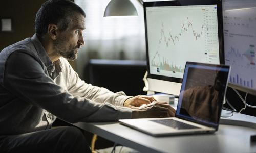 Professional looking at computer monitor in office setting.