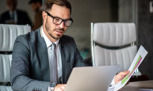 Professional looking at computer monitor in office setting.