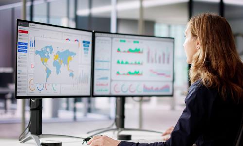 Professional looking at computer monitor in office setting.