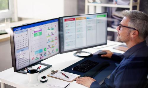 Professional looking at computer monitor in office setting.