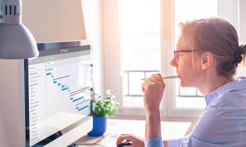 Professional looking at computer monitor in office setting.