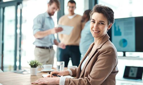 Professional looking at computer monitor in office setting.