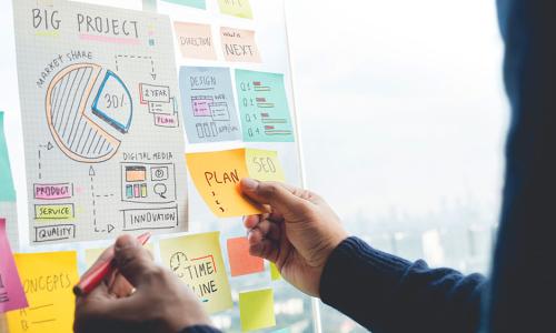 Professional looking at whiteboard in office setting.