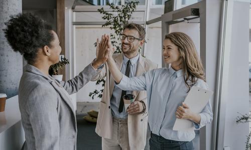 Group of professionals standing in an office setting.