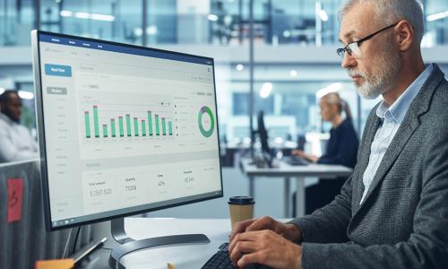 Professional looking at computer monitor in office setting.