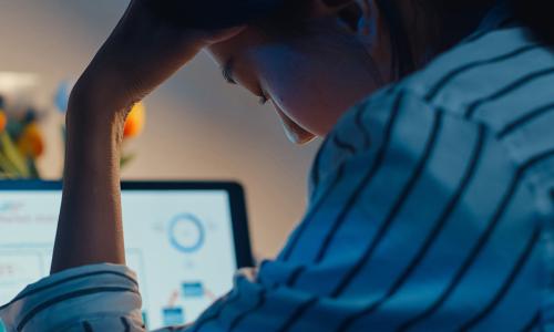 Professional looking at computer monitor in office setting.