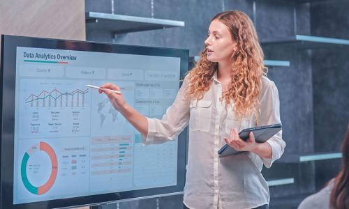 Professional looking at computer monitor in office setting.