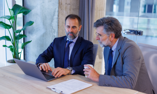 Two professionals happily reviewing project report