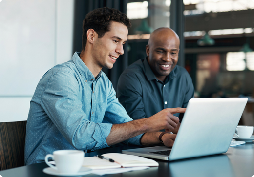 Two colleagues collaborating on a project, looking at laptop screen.