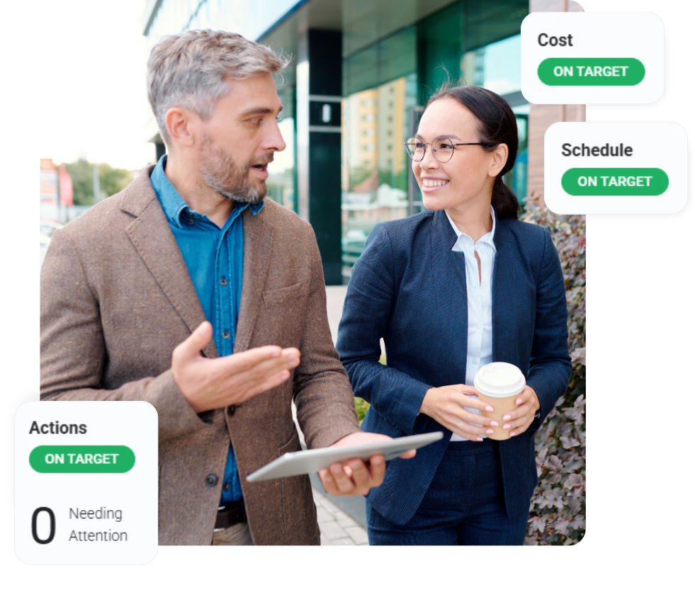 Two colleagues walking looking at tablet screen.